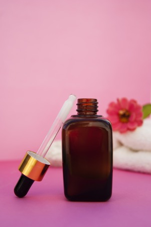 Beauty spa cosmetics, salon therapy concept. Glass cosmetic bottle on pink background.の写真素材