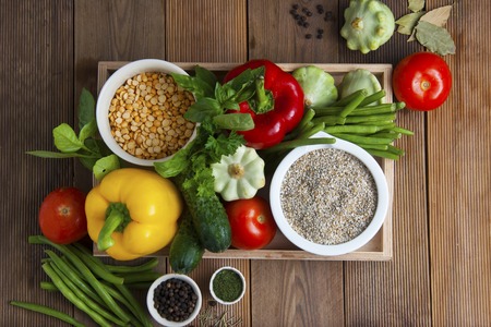 Health food with high fibre. Dietting, whole wheat cerals, grains, vegetables, antioxidants and vitamins: zzuchini, tomatoes cucumbers beans Wooden backgroundの写真素材