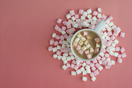 Cocoa drink with marshmallows isolated onpink or coral background, top view.の写真素材