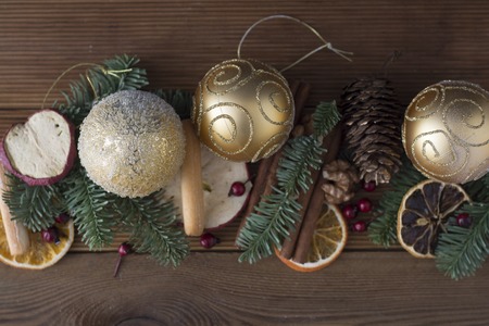 Christmas fir tree with decoration on dark wooden board background. Border art design with Christmas tree, baubles and light garlandの写真素材