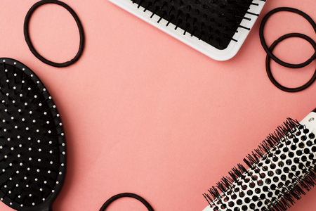 Used Hair brush tools on pink or coral background with copy space. Beauty fashion, hair care board.の写真素材