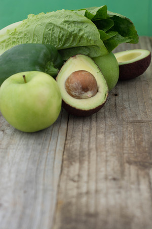 Close up of green vegetables and fruits rustic wooden background. Healthy food concept