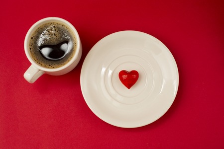 Cup of coffee Red heart on the white plate for Valentines day. Top view. Romantic gift with love.の写真素材