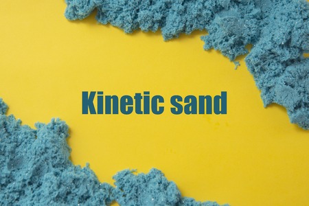 Abstract blue textured kinetic sand over yellow background. Kinetic sand word.の写真素材