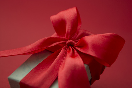 Close up gift box, birthday gift with red bow on red