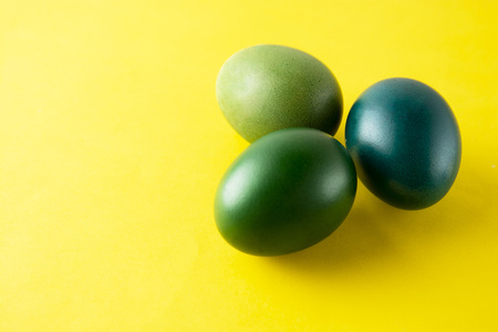 Green easter egg isolated on yellow background. Easter holiday concept. Stylish, colorful monochrome backgroundの写真素材