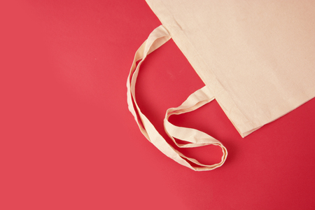 White tote canvas fabric, eco bag cloth shopping sack on colrful red background . Zero waste concept. No plastic bag pollution problem conceptの写真素材