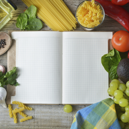 Fresh organic vegetables, wooden background and paper for Notes. Open notebook and fresh vegetables background. Dieting concept. Copy space.の写真素材
