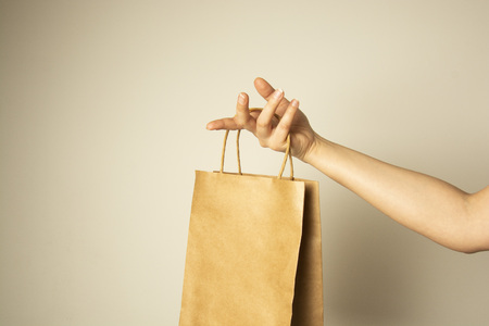 Closeup of female hand holding craft paper package., design mock up. Zero easte concept. No plastic. Protect planet.の写真素材