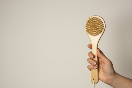 Hand holding Wooden body bath brush isolated on white background. Zero waste, no plastic.の写真素材