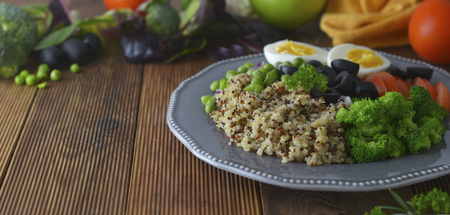 Layered vegetable salad with quinoa, green peas, broccoli, olives, red onion. Healthy food take away. Lunch foodの写真素材