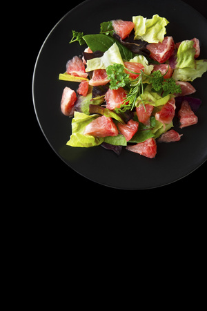 Healthy salad grapefruit and green leaves. Deliciouse dietary food. lose weigh. Salad in black plate. Copy space.の写真素材