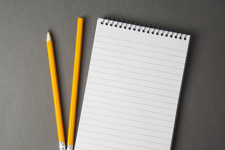 Notepad or notebook with pencil on gray background. Concept for education, business