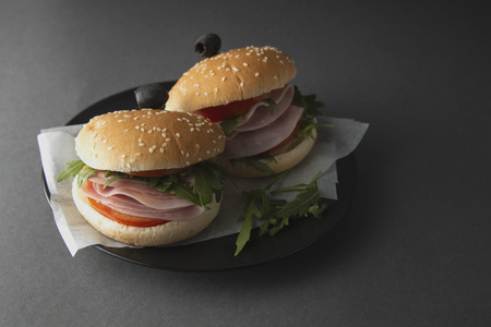 Hamburger with ham. Two burgers, hoemmade food. healthy sandwich with fresh vegetables on black...