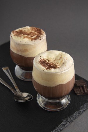 Coffee affogato with vanilla ice cream and espresso. Glass with coffee drink and icecream. Gray...