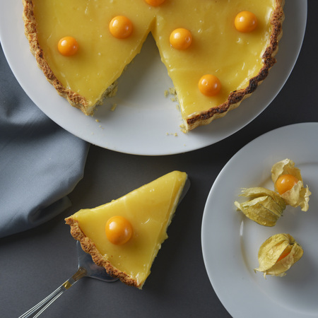 Lemon curd pie. Piece, slice of homemade delicious pie ,tart filled with lemon curd. Lemon curd pie decorated with physalis.の写真素材