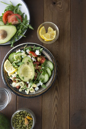Diet menu. Healthy salad of fresh vegetables - tomatoes, avocado, arugula, egg, spinach and quinoa on a bowl. Flat lay. Top view.の写真素材