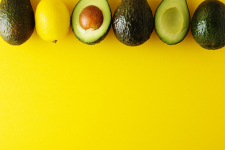 Ripe fresh avocado isolated on yellow background. Colorful healthy food background. Avocado...