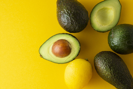 Ripe fresh avocado isolated on yellow background. Colorful healthy food background. Avocado...