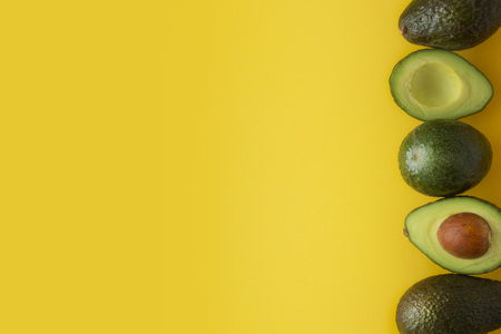 Ripe fresh avocado isolated on yellow background. Colorful healthy food background. Avocado isolated. Copy space.の写真素材