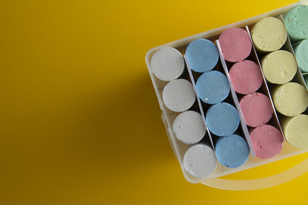 Abstract colorful chalks over yellow background with copy space. Education template. Creative childhod, business concept. Top view, copy space.の写真素材