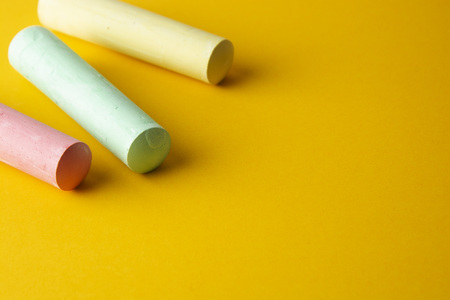 Education template. Colorful chalks over yellow background with copy space. Childhod, business and design. Top view, copy space.の写真素材
