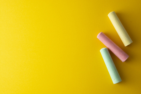 Education template. Colorful chalks over yellow background with copy space. Childhod, business and...
