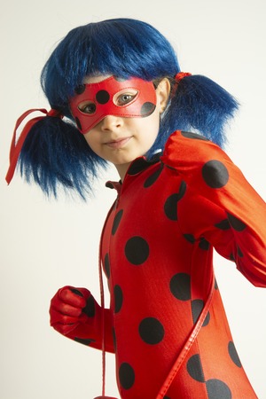 Corby, United Kingdom. March 12, 2019 - little girl in Ladybug Myraculous cosplay costume. Superhero ladybug with blue twig, isolaed.のeditorial素材