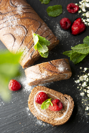 Delicious chocolate roll sponge cake with vanilla cream and mint leaves, Desert sweet foodの写真素材