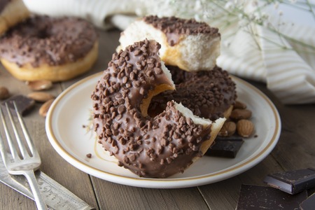 Chocolate donuts breakfast or dessert, wooden table. Close up glazed donuts.の写真素材