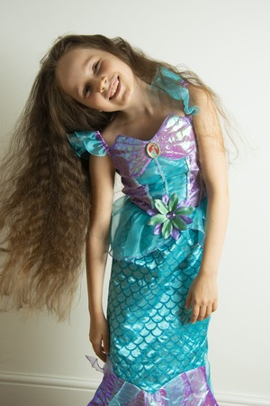 Corby, United Kingdom. March 12, 2019. Little girl with long hair, dressed as mermaid. Little Mermaid cosplay costume. Disney movie character. Copy space.のeditorial素材