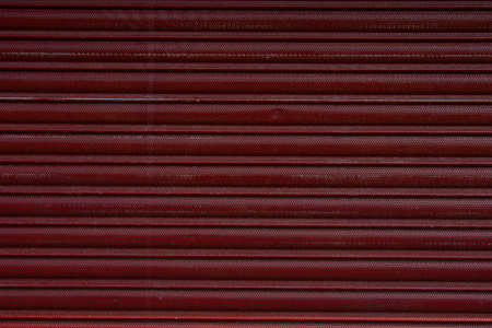 Close up of a roller shutter door, plastic red texture