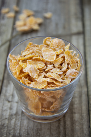 Bowl with cornflakes on grey wooden background