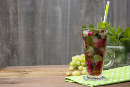 Fresh fruit tea in glass cup with straw, summer fruit tea drink, wooden background, healthy drink. HD video.の写真素材