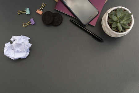Creative flat lay of workspace desk with notebooks, smartphone, papper, succulent plant. Grey background. Copy space.の写真素材