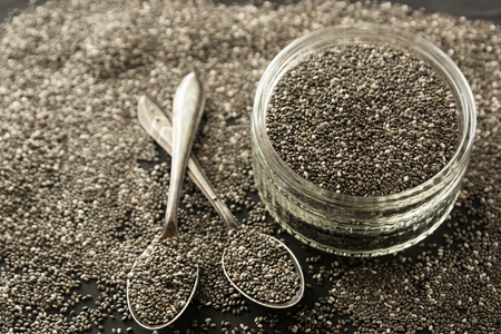 Chia seeds in glass bowl isolated, wooden background, selective focus. Dark background.の写真素材