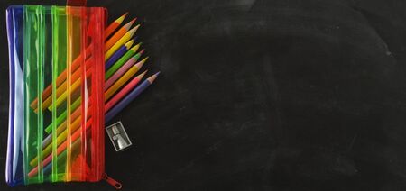 Back to school banner. Rainbow pencil case with school supplies for student. Black background.
