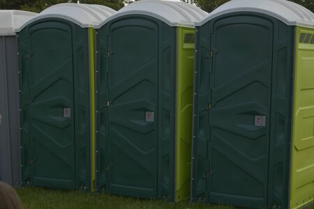 Row of mobile green bio toilets outside in the park.の写真素材