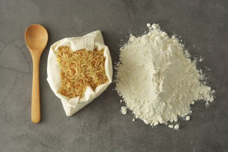 Rice flour and rice over dark background. Gluten free flour for healthy pastry.の写真素材
