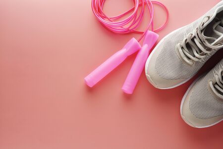 Sneakers, sport shoes and jumping rope over pink background. Health, running workout, fitness and yoga concept. Space for text.の写真素材