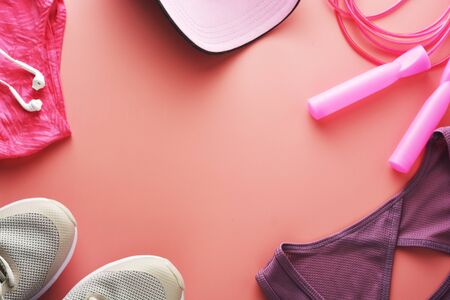 Workout concept, flat lay with copy space. Sport shoes, jumping rope, yoga clothes over pink background. Health, running workout, fitness and yoga concept.の写真素材