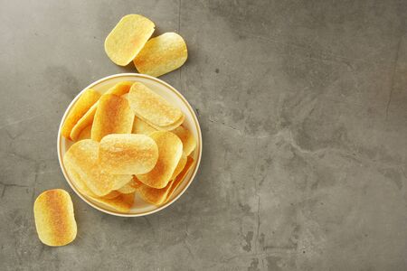 Crispy potato chips isolated over grey textured background. Flat lay.の写真素材