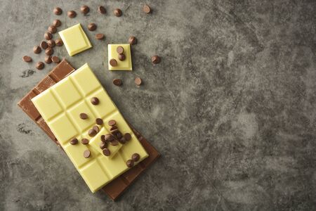 White and milk chocolate isolated. Top view of various chocolate bars, copy space.