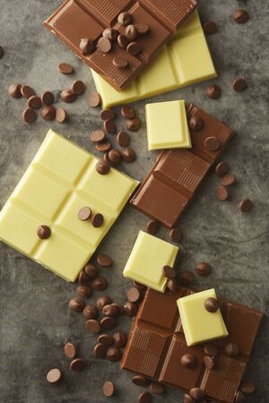 White and milk chocolate isolated. Top view of various chocolate bars, copy space.