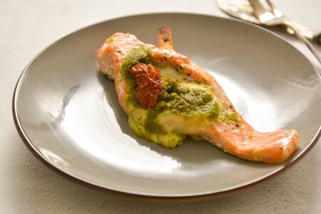 Baked salmon with cherry and pesto, isolated in stylish plate. Healthy foods.の写真素材