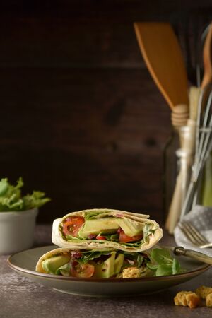 Tortilla wraps with avocado, cherry tomato. Healthy, vegan food. Take away snack, isolatedの写真素材