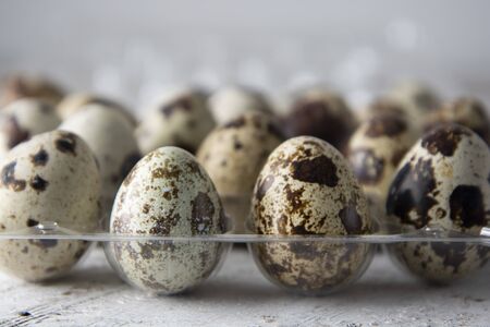 Quail eggs over white wooden background. Isolated quail raw eggs. rustic style. Healthy food ingredient.の写真素材