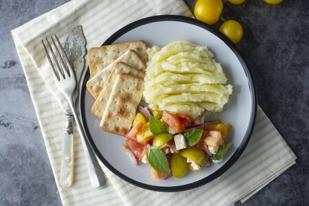 Tomatoes fresh salad and mushed potatoes in a plate. Healthy food.の写真素材