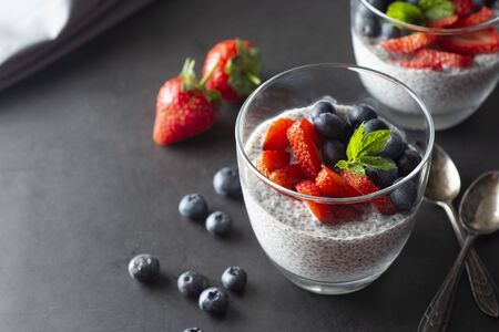 Healthy chia pudding in a glass with fresh berries. Healthy breakfast. Dark photo food.の写真素材