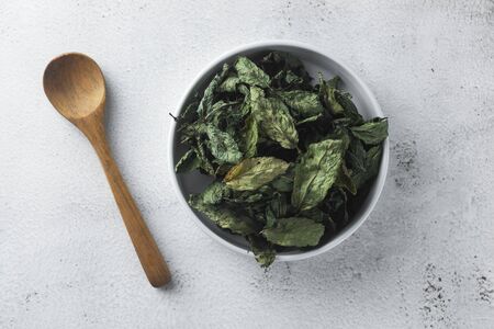 Mint Tea. Dry mint leaves in bow, over light background, isolated.